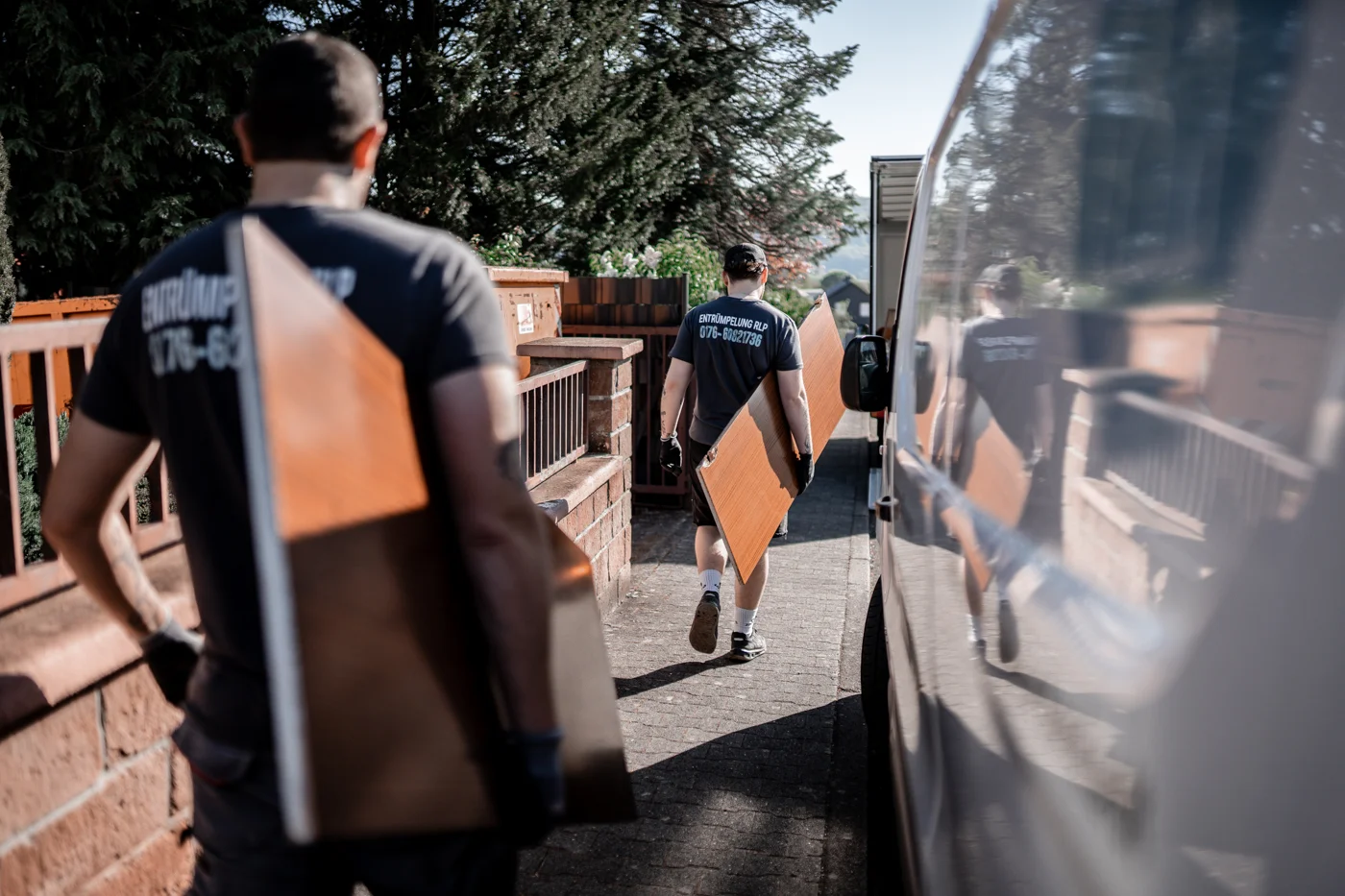 Mitarbeiter von Entrümpelung RLP tragen Möbelteile zur Entsorgung